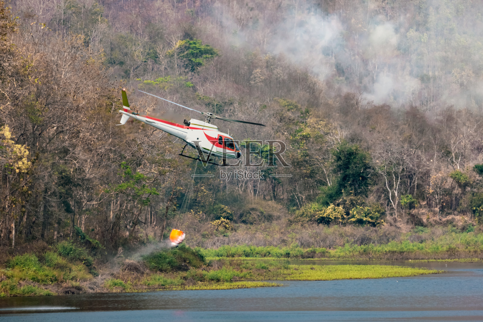 消防直升机携带水来扑灭森林大火照片摄影图片