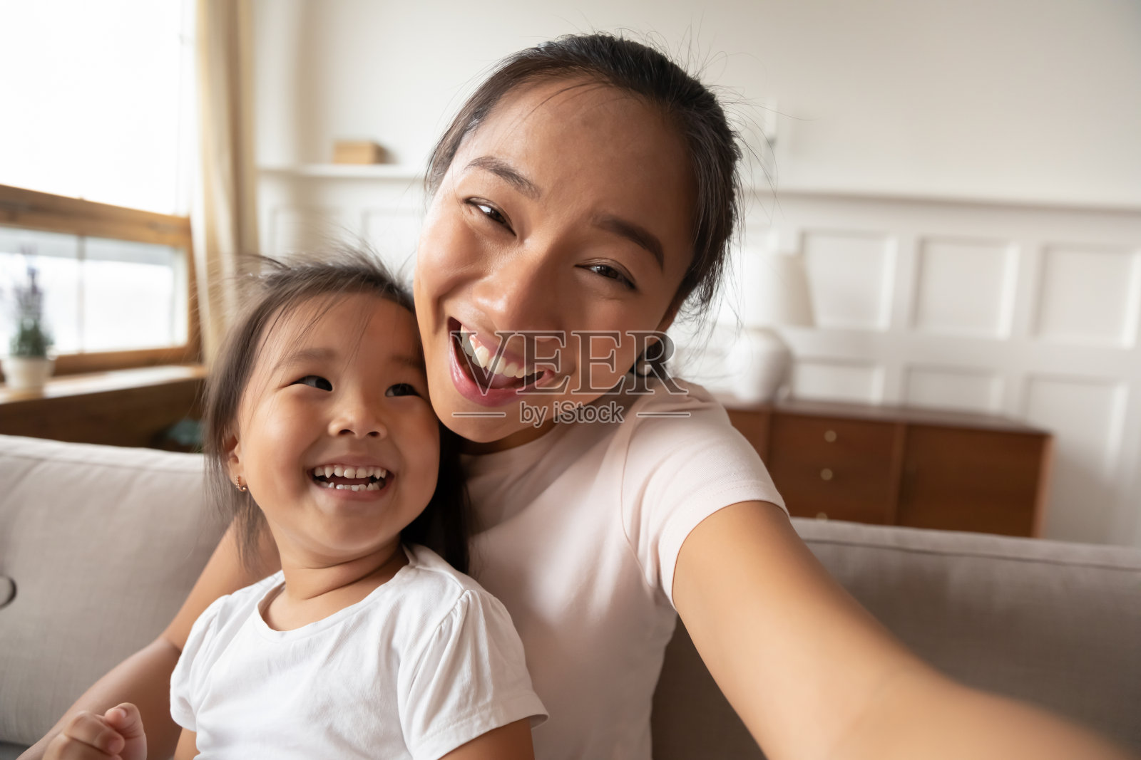 近距离微笑的亚洲母亲和小女孩自拍照片摄影图片