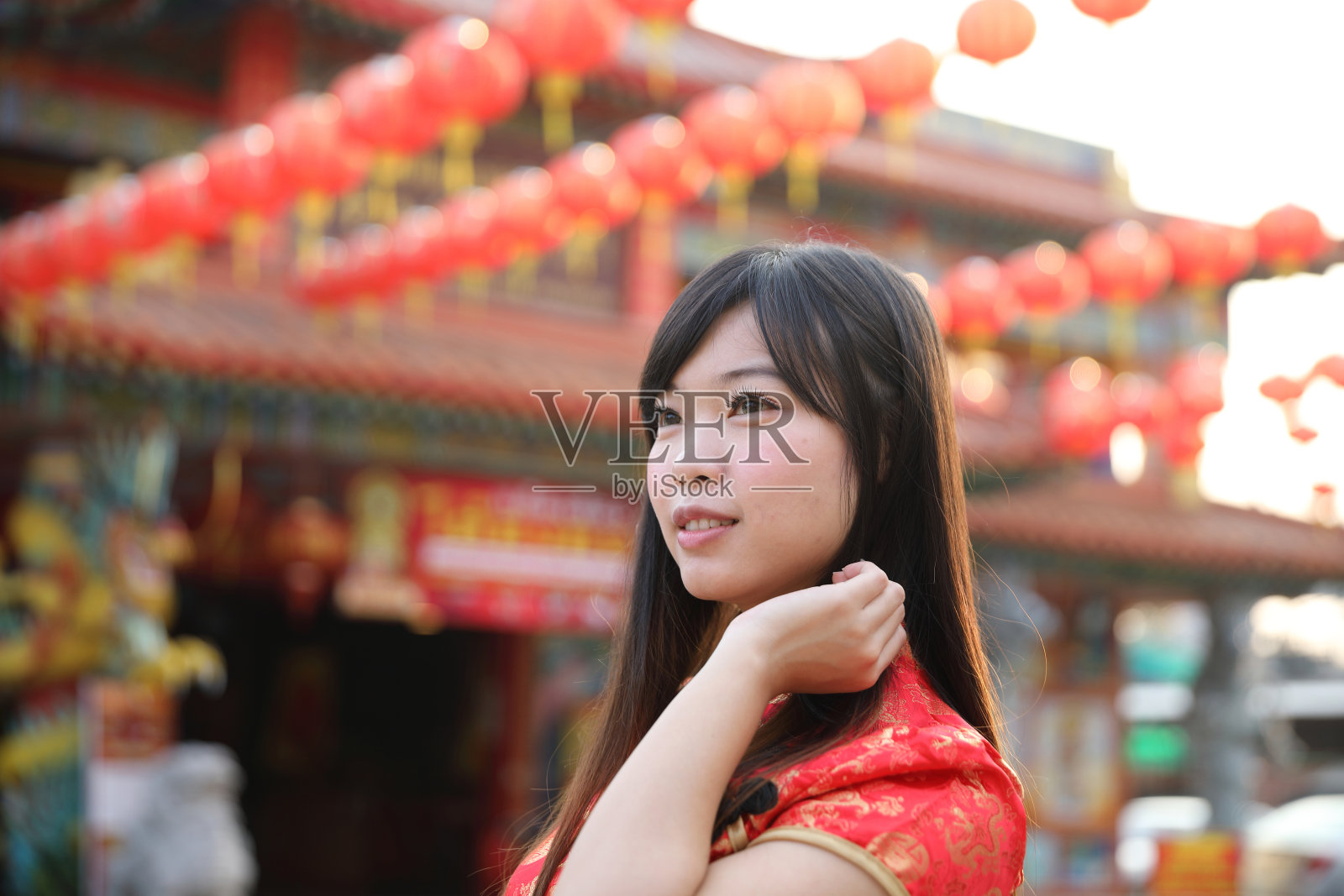 美丽的女人穿着红色旗袍看着和微笑在中国新年照片摄影图片