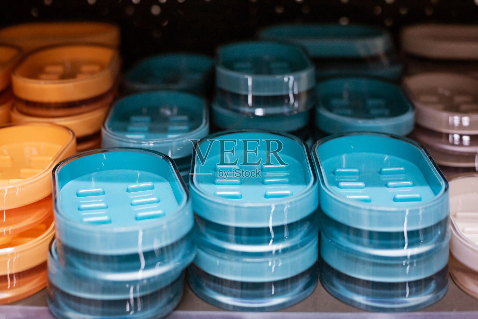 五颜六色的塑料肥皂盒排列在商店的货架上照片摄影图片