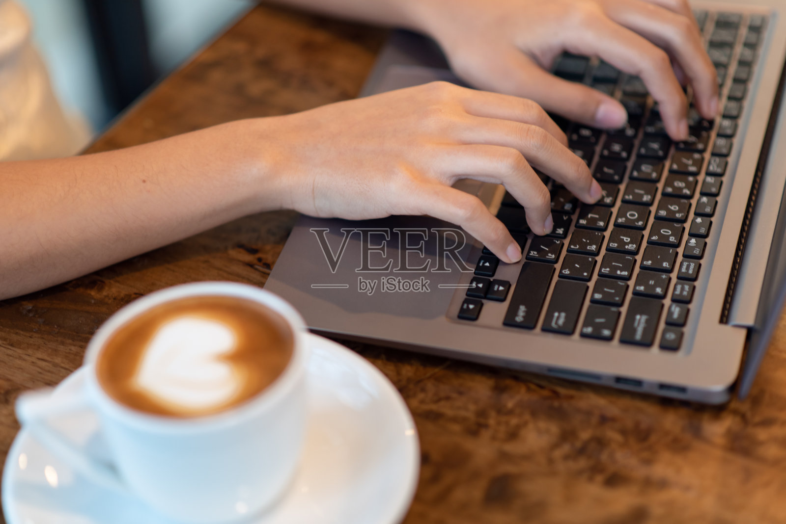 一个女商人的近距离打字在一个笔记本电脑在办公室与一杯咖啡照片摄影图片