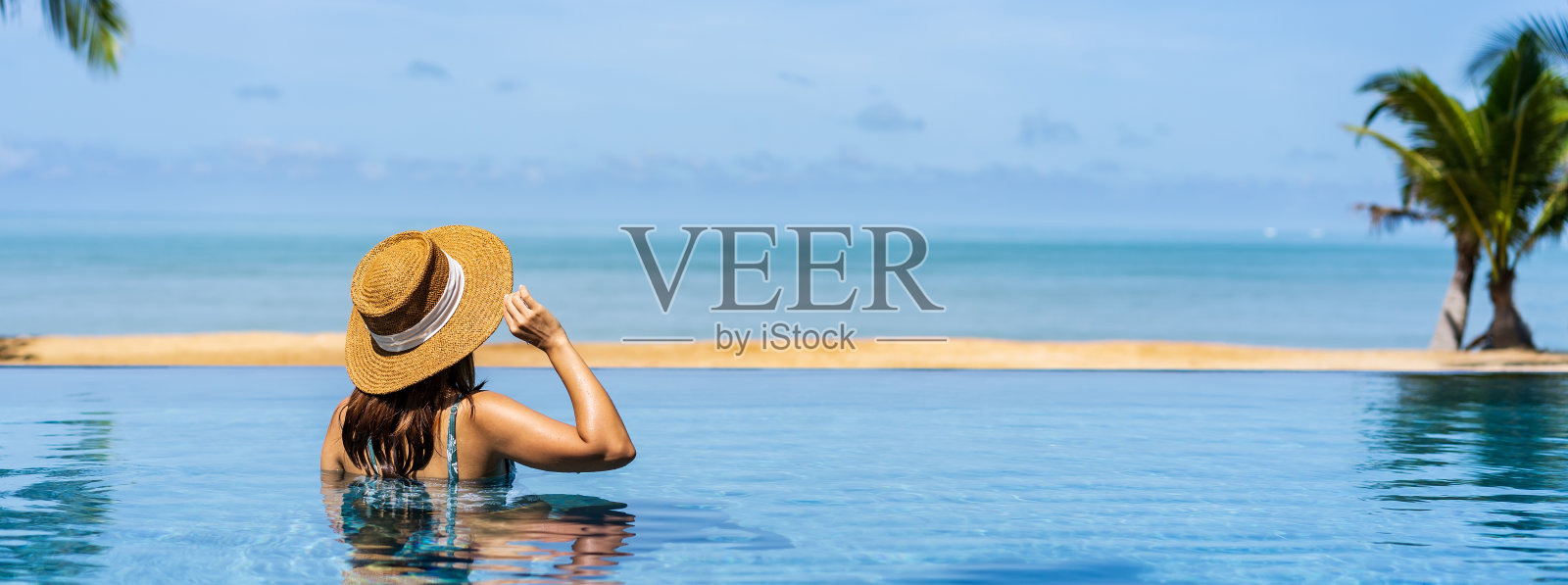 年轻的女人旅行者放松和享受在一个热带度假泳池，旅行的概念，横幅全景照片摄影图片