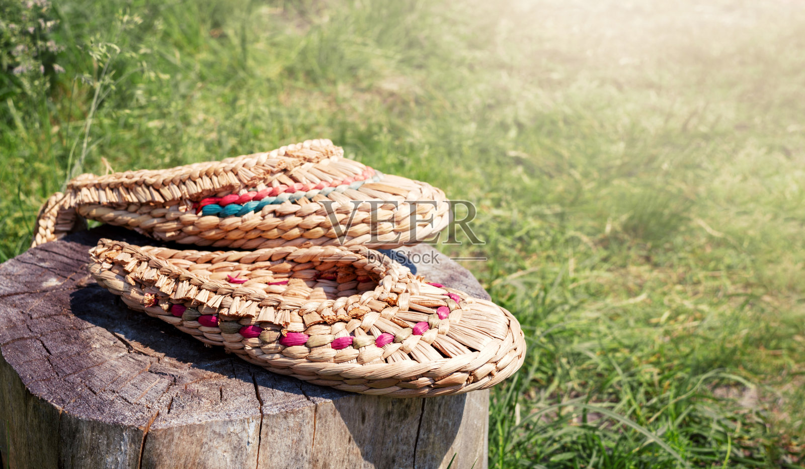 用天然材料编织而成的树皮鞋躺在自然模糊的背景上，复制空间。用于桑拿或洗澡的手工拖鞋。照片摄影图片