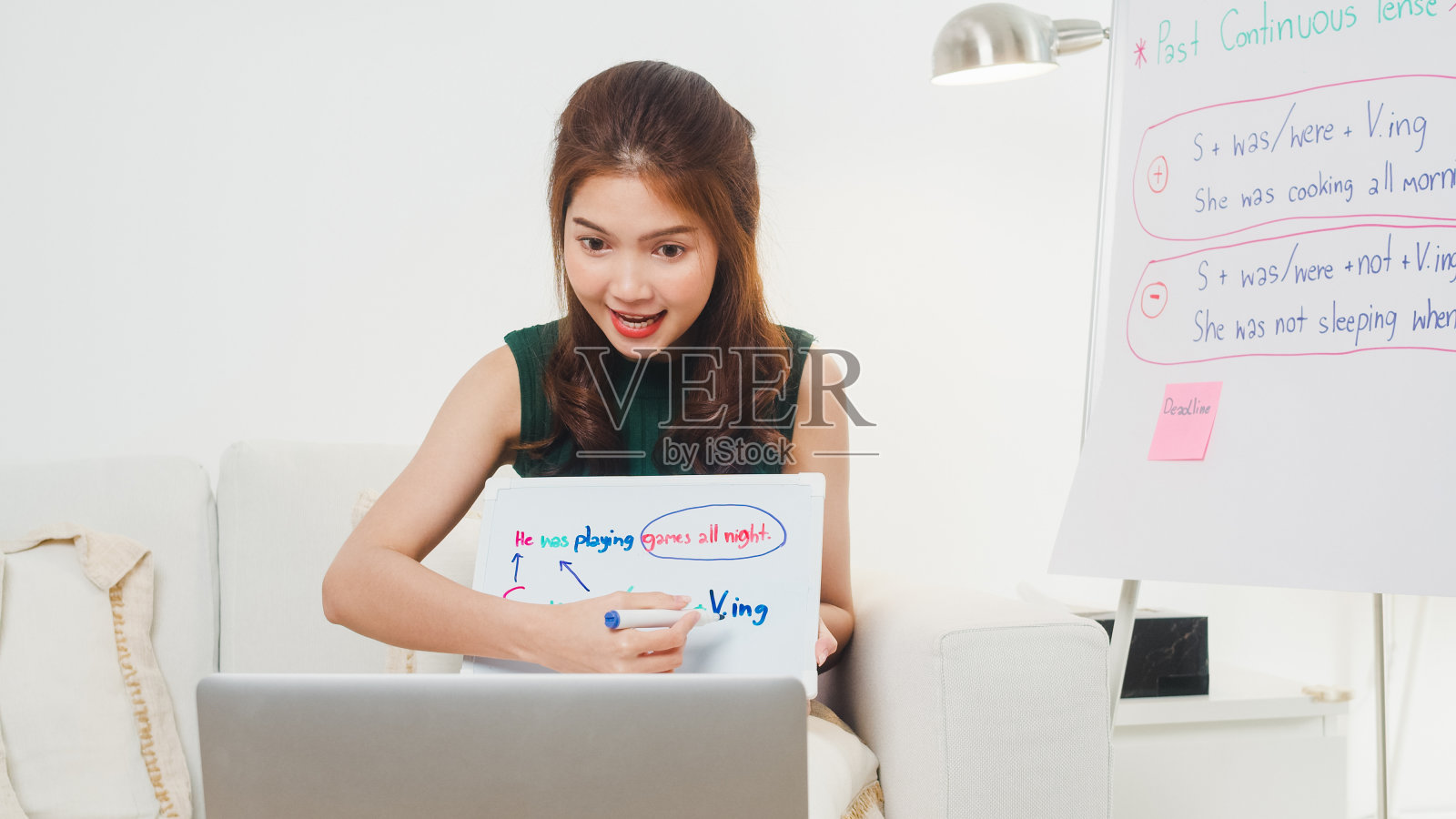 亚洲年轻女英语教师在电脑上视频会议，通过笔记本电脑聊天，通过网络摄像头学习教学。照片摄影图片