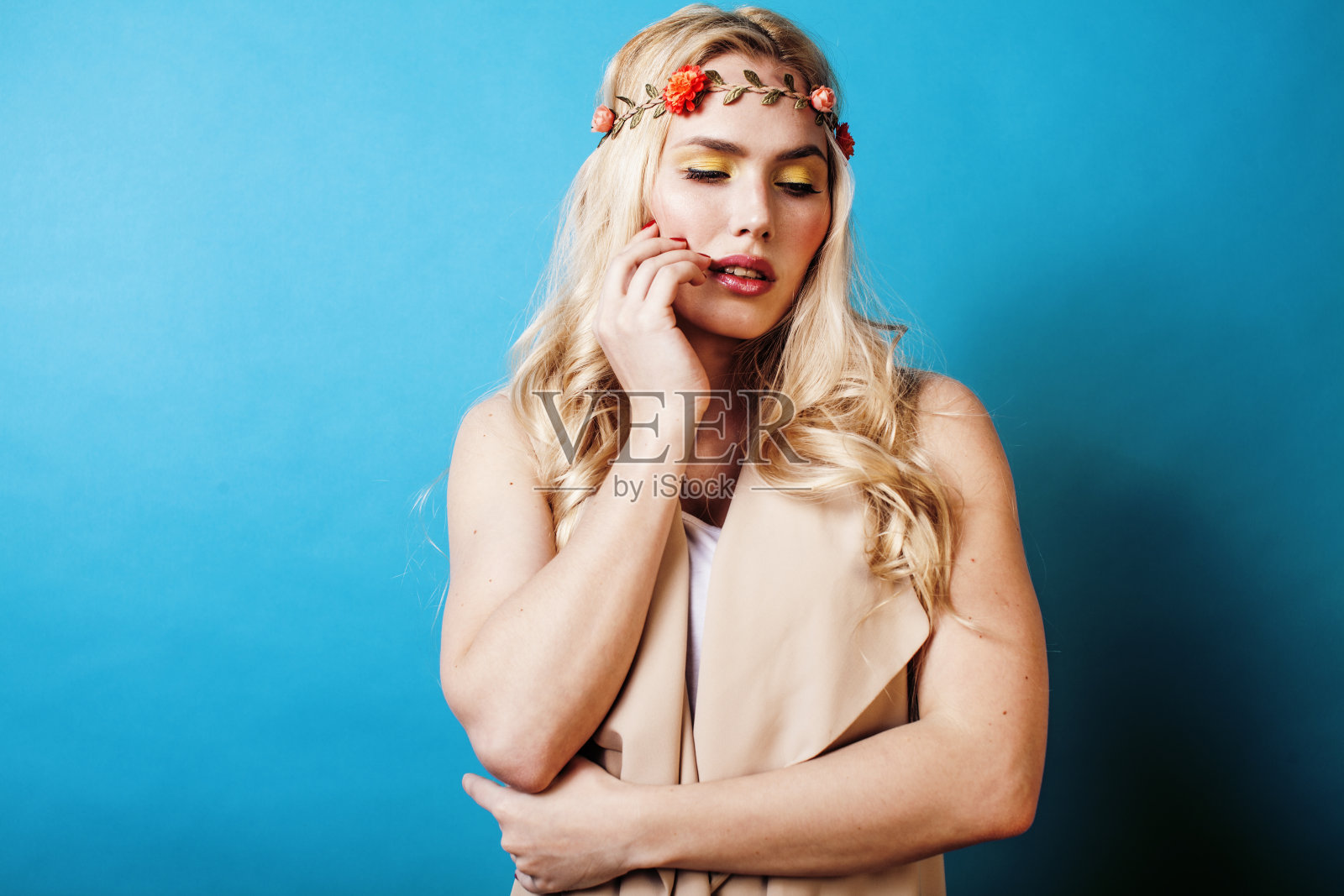 年轻的金发女子打扮得像古希腊女神，珠宝近距离隔离，美丽的女孩双手修剪红指甲上的蓝色背景copyspace照片摄影图片