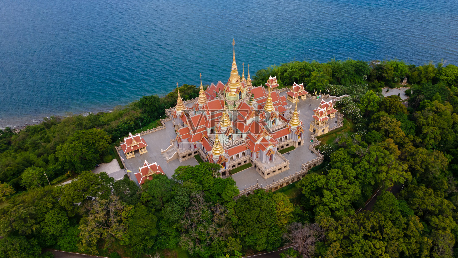 在蓝色海滩附近的山林中，无人机拍摄的Wat pramahathchedi Pakdeeprakad或Tang Sai寺庙的高空角度景观照片摄影图片