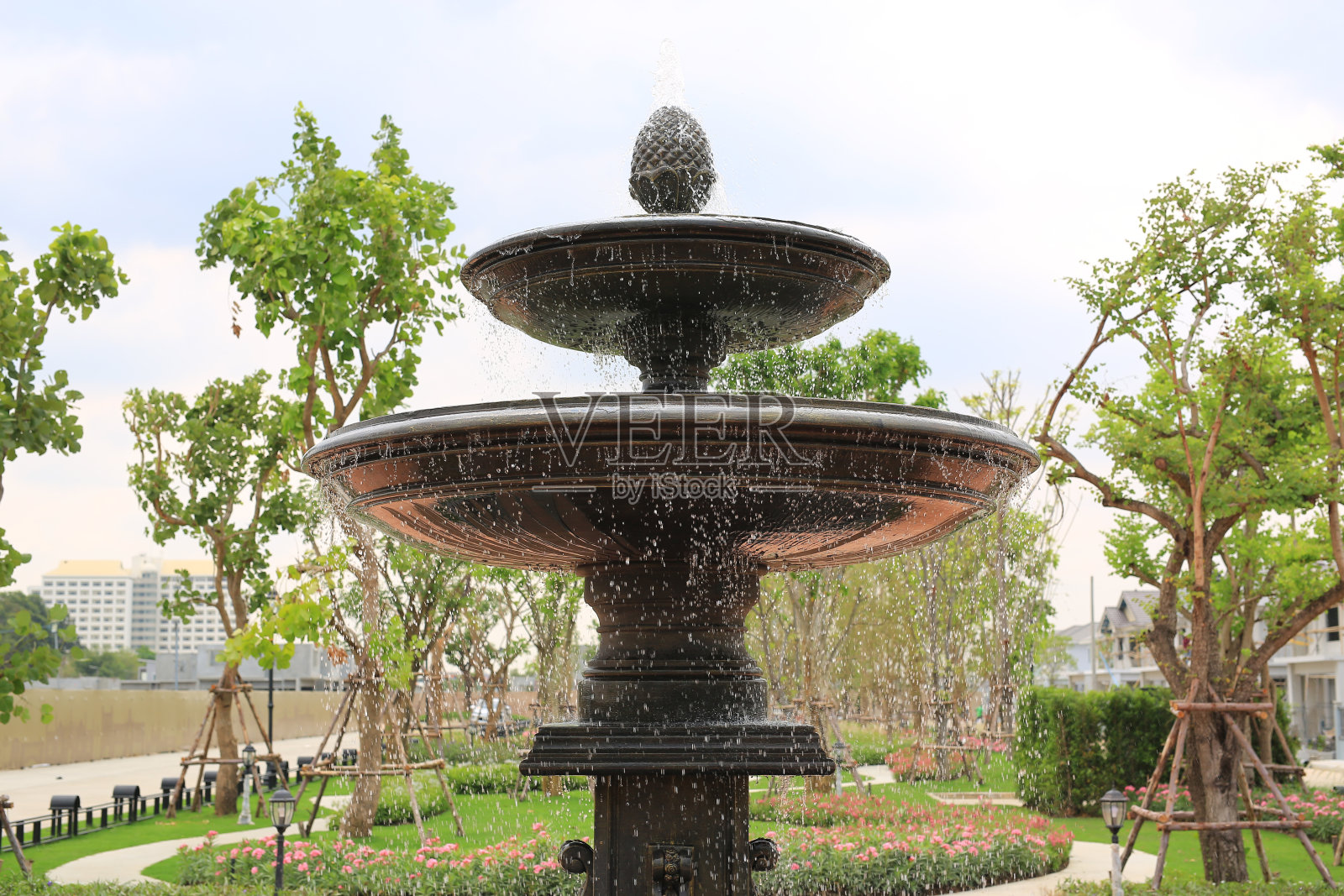 美丽的喷泉在公园的花园里。水从喷泉中流出。照片摄影图片