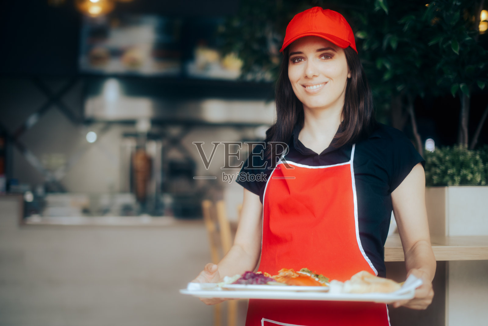 拿着食物托盘的快乐女服务员在餐馆工作照片摄影图片
