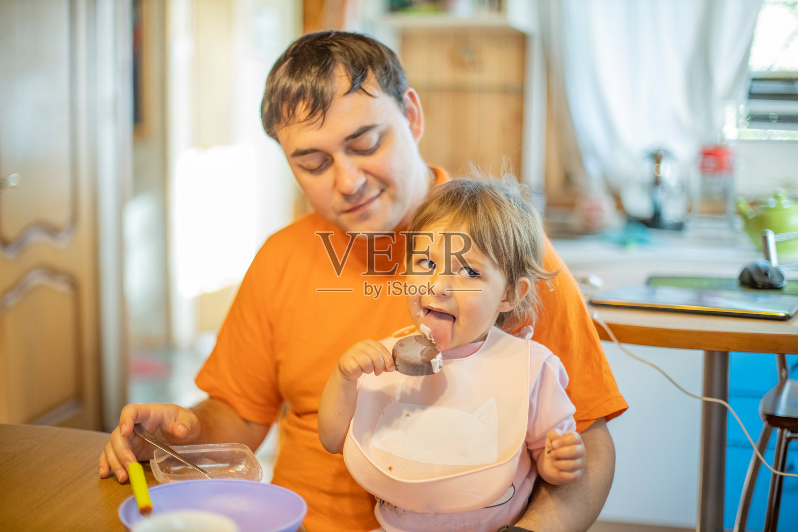 父亲在家给婴儿喂奶。单身父亲照片摄影图片