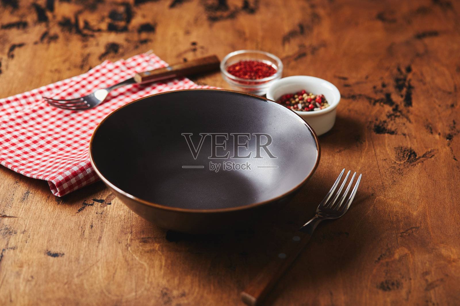 空的黑色碗与叉子，餐巾和香料木制背景照片摄影图片