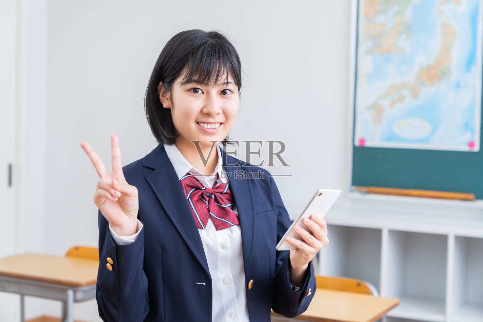 亚洲女学生在教室里学习，智能手机，制服，照片摄影图片