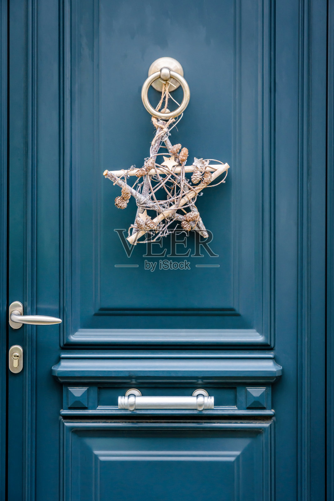 一种星形的圣诞装饰挂在蓝色的前门与门框。照片摄影图片