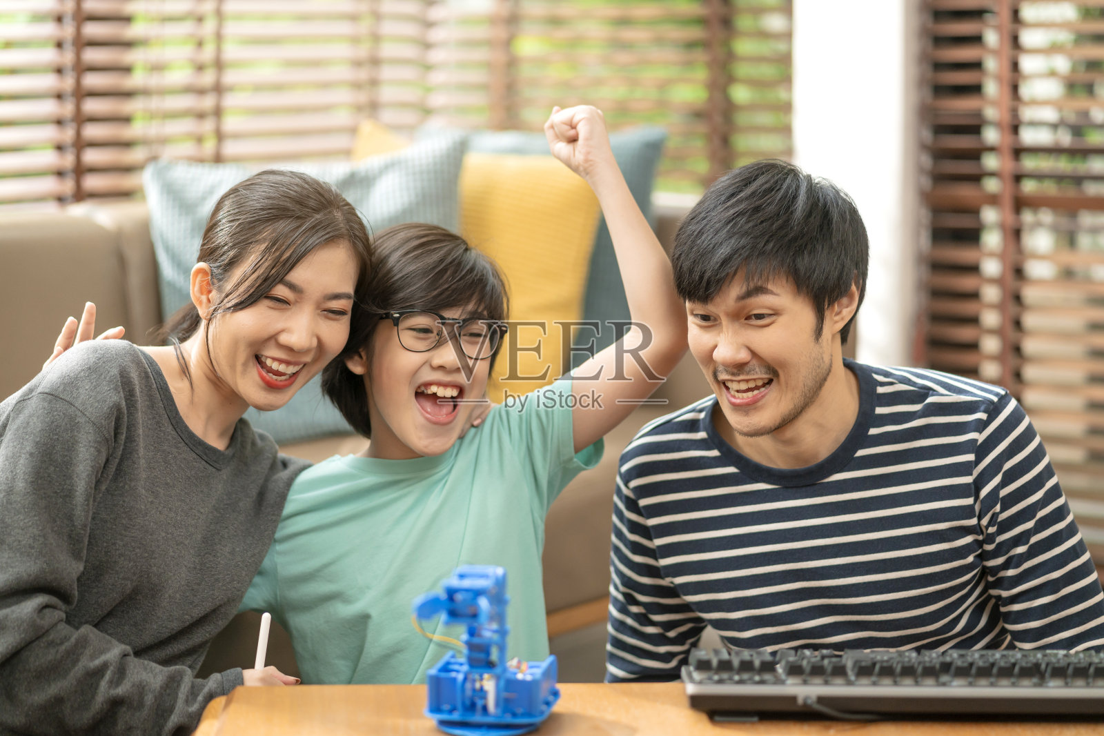 在家里学习概念，亚洲男孩和妈妈成功控制机器人手臂上的数字平板电脑和电脑键盘，快乐的家庭得到了在家里编程控制机器人的教训照片摄影图片