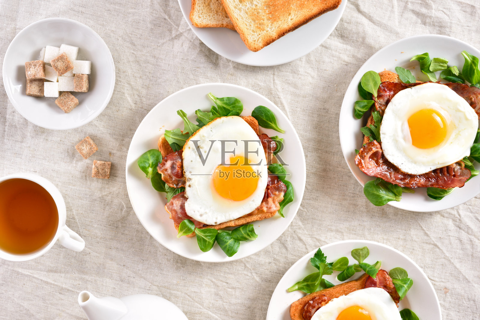 用煎蛋、咸肉和蔬菜叶子做成的三明治照片摄影图片