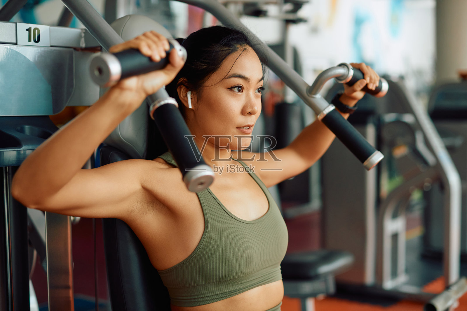 亚洲女运动员做重量练习为上半身力量在体育训练在健身房。照片摄影图片