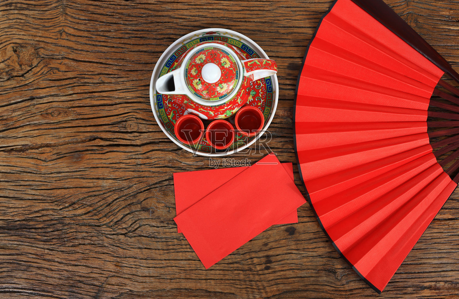 中国文化和生活理念。水平背景的中国新年，红包和热茶décor与红色的扇在木地板上照片摄影图片