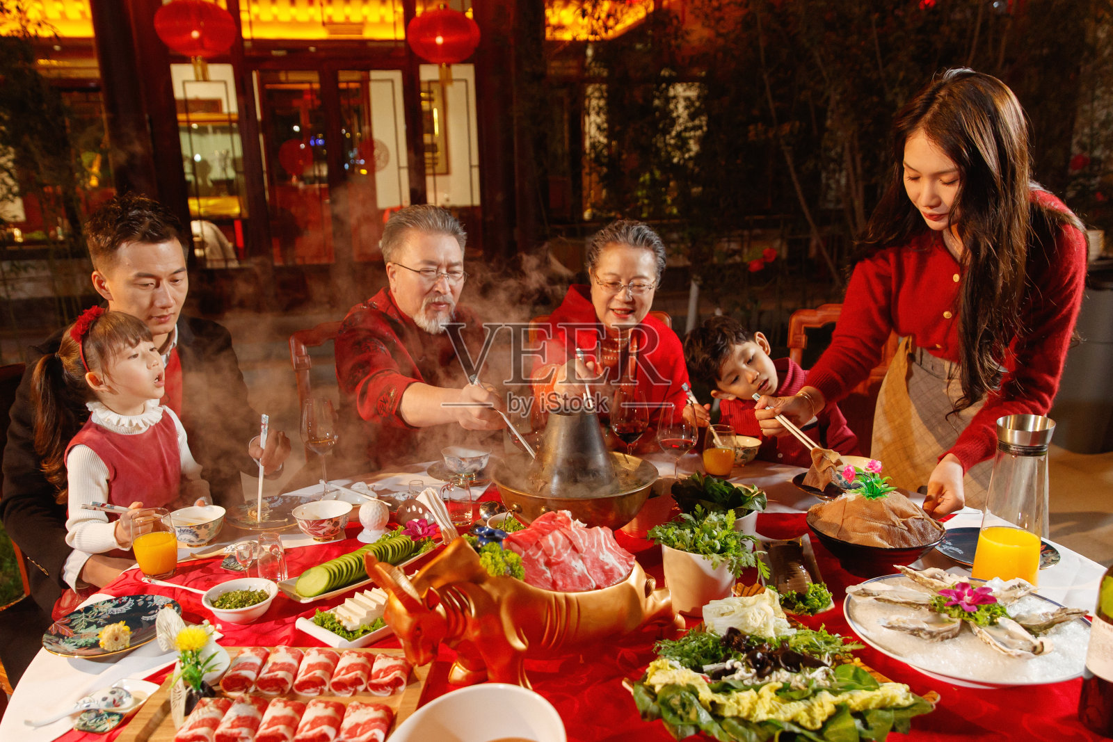 春节东方家庭在中式庭院内聚餐照片摄影图片