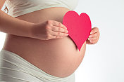 孕妇腹部和红心上白图片素材