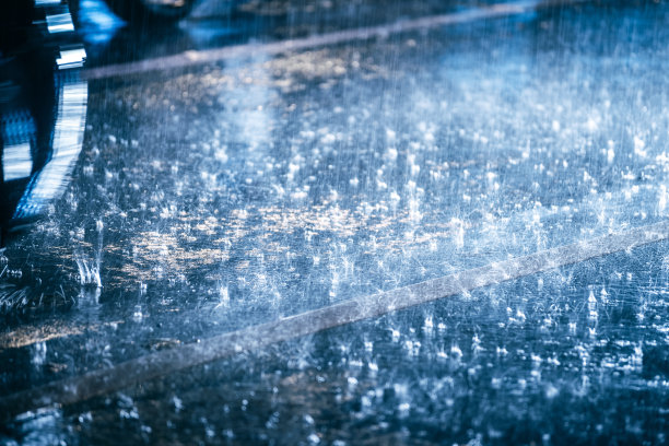汽车在雨中驾驶在潮湿的道路上带着前灯图片下载