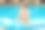在游泳池里的蓝色充气床垫上微笑的男孩素材图片
